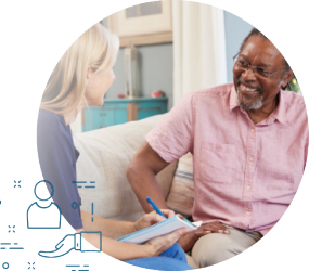 Une personne est assise près d'une autre sur un sofa. Elle prends des notes.