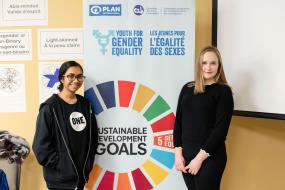 Deux personnes se tiennent debout devant une affiche des ODD.