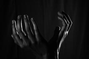 Photographie de mains avec une posture suggérant le désespoir.
