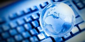 Un globe terrestre translucide flotte au-dessus d'un clavier d'ordinateur.