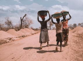 Photographie de trois personnes dans un camp de réfugiés.