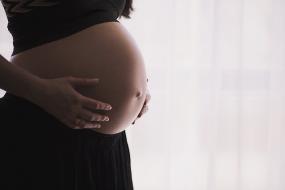 Photographie en gros plan sur le ventre d'une femme enceinte.