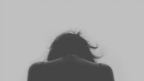 Vue de dos d'une personne, la tête penché vers l'avant.
