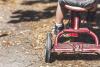 Photographie en gros plan d'un enfant sur un tricycle.