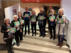 Photographie du lancement. Les participantes et participants, en demi-cercle, font face à la caméra avec un exemplaire du livre entre leurs mains.