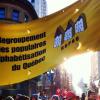 Une bannière à l'éfigie du Regroupement des groupes populaires en alphabétisation du Québec au dessus d'une foule de manifestant-e-s